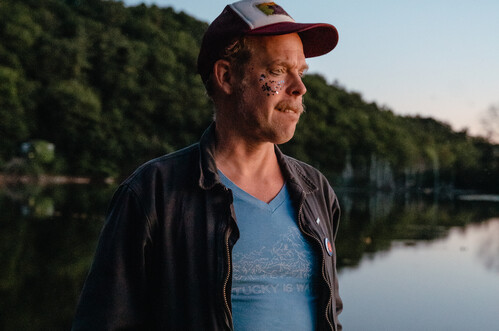 Bonnie Prince Billy standing by a lake