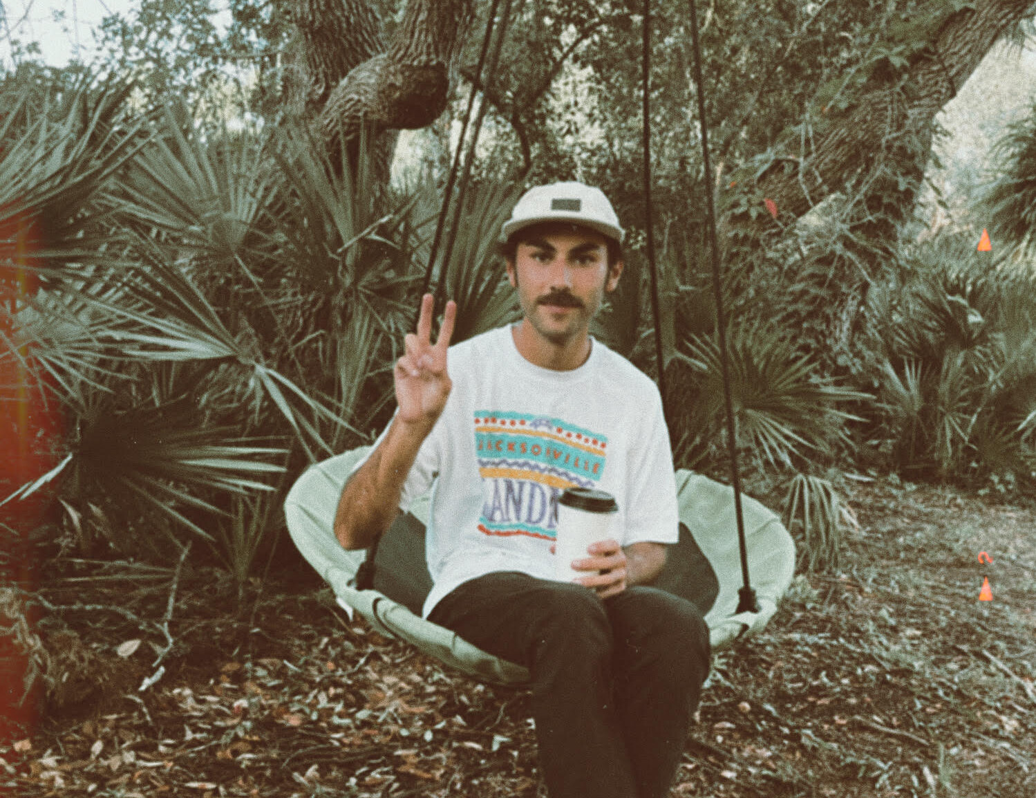 Micah George, aka Chalooby, sitting in a hammock swing